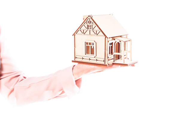 building houses in a mortgage, a woman with a model of a house on her hand, isolate - Фото, изображение