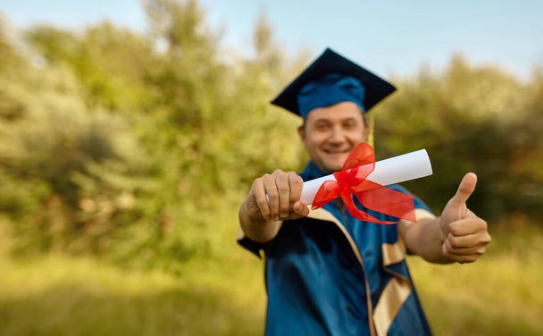 Крупним планом випускник піднімає руки і святкує з сертифікатом в руках і відчуває таке щастя в День Подяки, Концепція успіху освіти
 - Фото, зображення