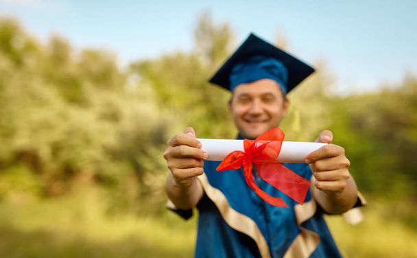 Gros plan main de diplômé mettre ses mains en l'air et célébrer avec certificat dans les mains et se sentir si heureux dans le jour du début, Concept de réussite scolaire - Photo, image