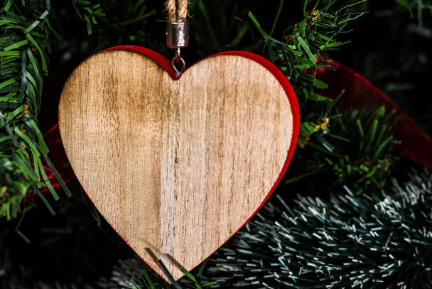 A closeup shot of a wooden heart ornament on a Christmas tree - Fotografie, Obrázek