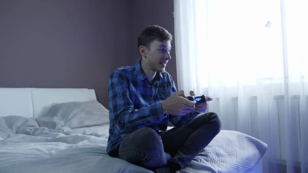 Man holding video game console controlling joystick, playing games online at home - Video