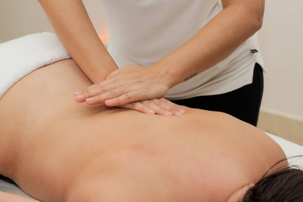 A closeup shot of a woman lying on her stomach getting a spine massage - Фото, зображення