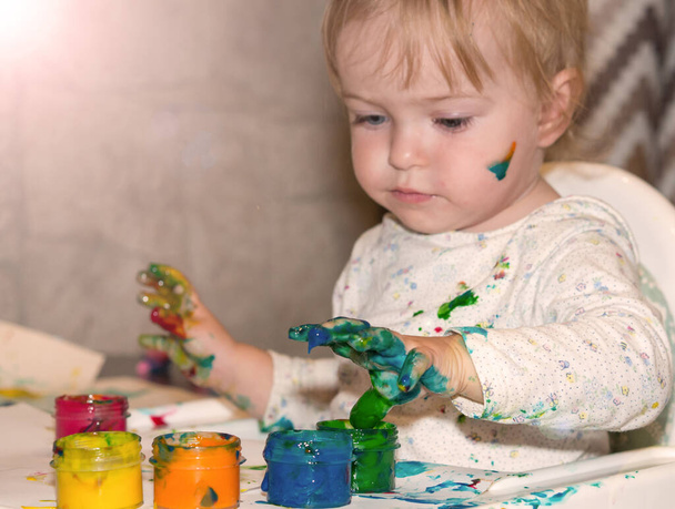Coloración de dedo para niños. Una niña dibuja con pinturas con las manos sobre el papel. Concepto de desarrollo infantil. - Foto, Imagen