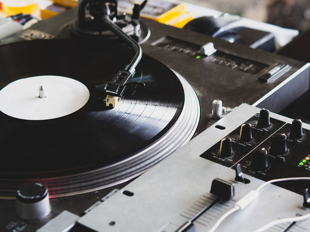 DJ legt Musik auf einer Hip-Hop-Party auf. analoger Plattenspieler, DJ verwendet Plattenspieler und Mixer zum Kratzen. - Foto, Bild