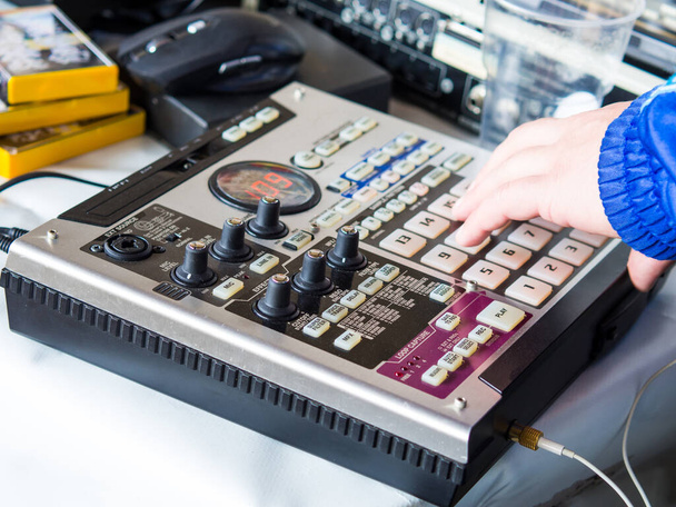 making hip hop beats on a drum machine controller and turntables in a home studio - 写真・画像