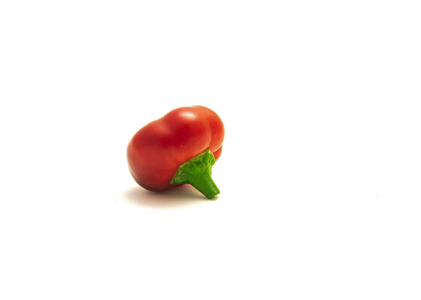 Одиночний червоний стиглий гарячий вишневий перець або піміо у формі серця перець чилі ізольований на білому
 - Фото, зображення