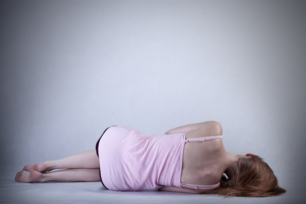 Skinny girl lying on the floor - Фото, изображение