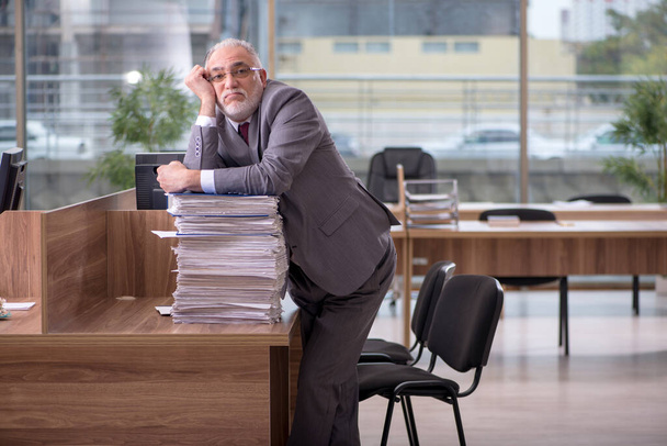 Ein alter Geschäftsmann und zu viel Arbeit im Büro - Foto, Bild
