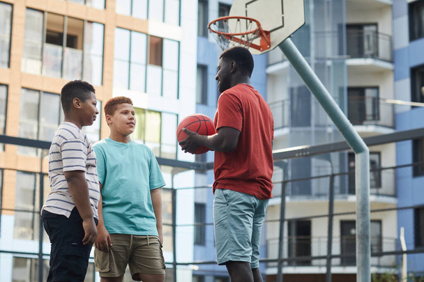 バスケットボールのルールを10代の男の子に説明する - 写真・画像