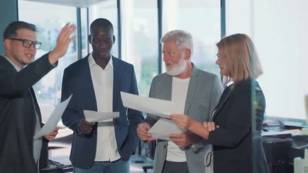 drie zakenmannen in een modern kantoor, een jonge man, een Afrikaanse zakenman en een vrouw - Video