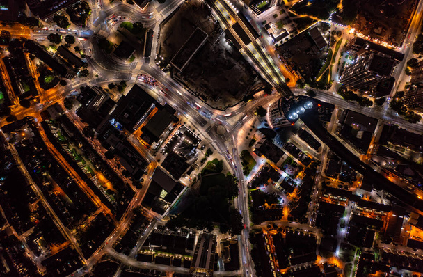 ロンドン市内の照明で夜の街を移動する影や車と背の高い金融や商業ビルの鳥の目のビュー - 写真・画像