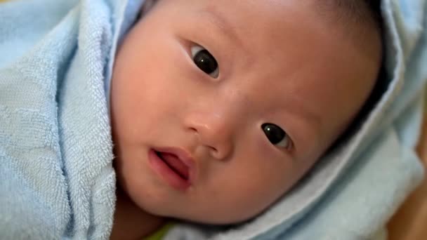 Pieni söpö Aasia vauva poika peitetty pyyhkeellä. - Materiaali, video