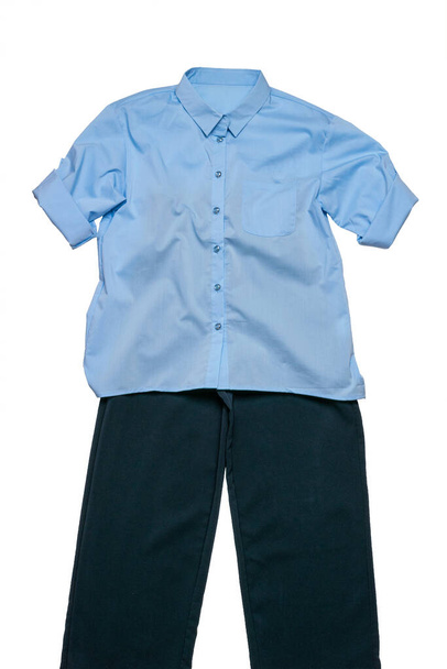 Niebieska koszula i ciemne spodnie odizolowane na białym tle. Klasyczna odzież. - Zdjęcie, obraz