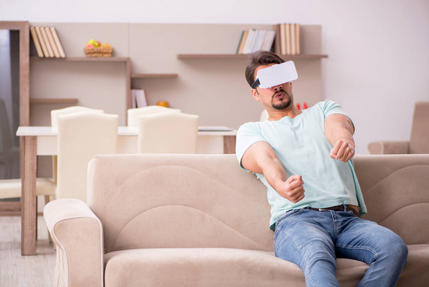 Jeune homme étudiant portant des lunettes virtuelles à la maison - Photo, image