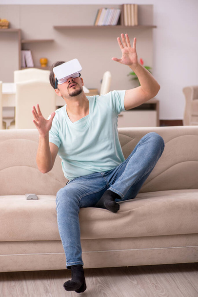 Young man student wearing virtual glasses at home - Фото, изображение