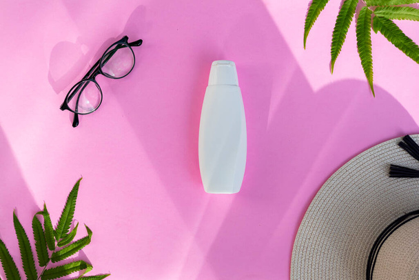 Recipiente de garrafa cosmética branca sobre fundo de papel rosa. Conceito de produto de beleza orgânica natural, styl de verão minimalista - Foto, Imagem
