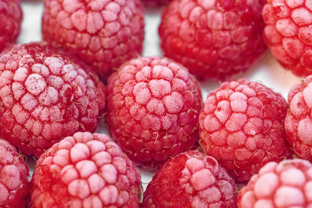 frozen red raspberries on background, close up - Fotó, kép