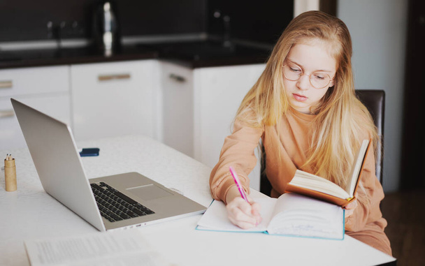 Portrait of young girl doing her school work with laptop - Zdjęcie, obraz