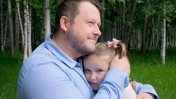 Hymyilevä isä halaa hellästi pientä tytärtään, 3-vuotiasta, nauttien isyydestä. Isänpäivä. Onnellinen lapsuus ja vanhemmuus käsite. Lastensuojelu - Valokuva, kuva