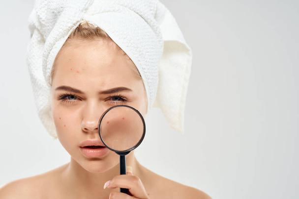 woman with bare shoulders with towels talking skin problems magnifier near face - Photo, Image