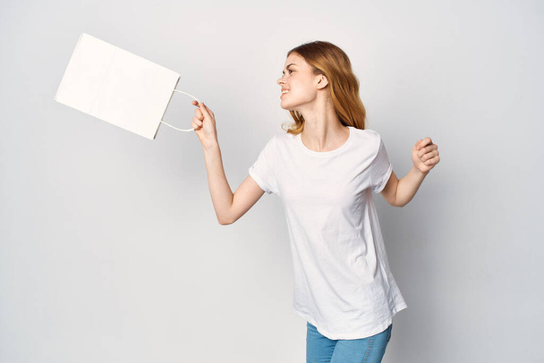 pretty woman in white t-shirt shopping bag in hands - Fotoğraf, Görsel