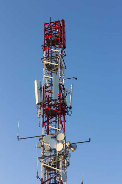 Antenne de télécommunications multicolore au sommet d'une montagne. Communication numérique moderne - Photo, image