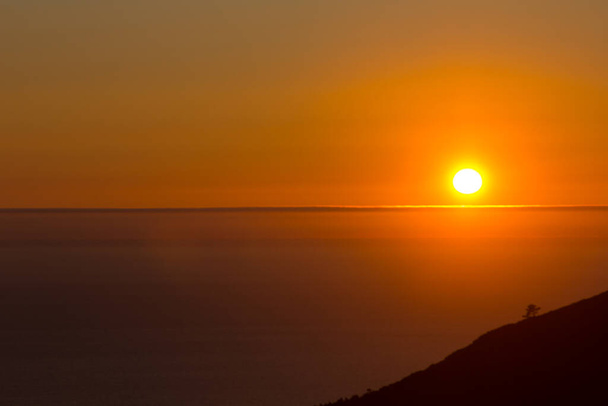 Tonos anaranjados al atardecer sobre el Océano Atlántico, Galicia, España, frente a la Ría de Arosa. Oeste es la dirección en la que el sol se pone. - Foto, imagen