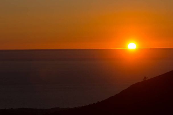 Tonos anaranjados al atardecer sobre el Océano Atlántico, Galicia, España, frente a la Ría de Arosa. Oeste es la dirección en la que el sol se pone. - Foto, imagen