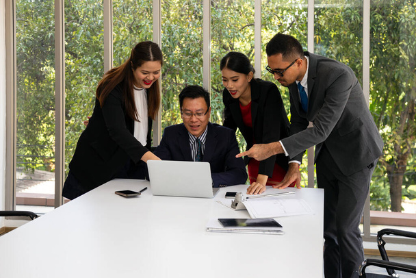 Менеджер и бизнес-команда проверяют информацию в ноутбуке по сравнению с голубым принтом счастья. работа с партнерами и инженерными инструментами в конференц-зале - Фото, изображение