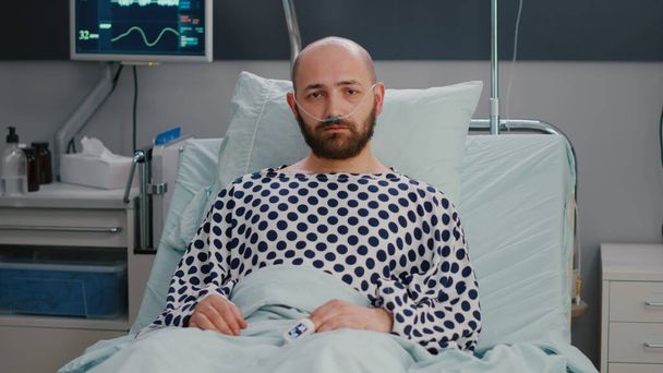 Potrait hospitalizovaného nemocného muže s nosní kyslíkovou trubicí s respirační poruchou - Fotografie, Obrázek