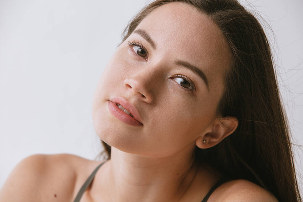 Close-up retrato de belo rosto feminino sem maquiagem isolada sobre fundo cinza - Foto, Imagem