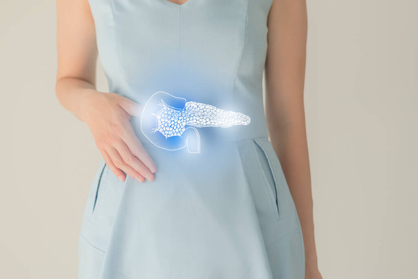 Unrecognizable female patient in blue clothes, highlighted handrawn pancreas. Human digestive system issues concept. - 写真・画像