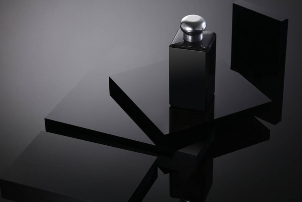 Blank Bottle Cosmetics on crystal black square podium background. Pedestal for display. Platform for design, concept blank scene stage showcase for new product, banner, promotion sale, event, museum. - Photo, Image