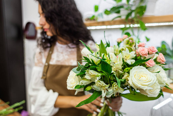 Attractive young woman florist is working in a flower shop. - Fotografie, Obrázek