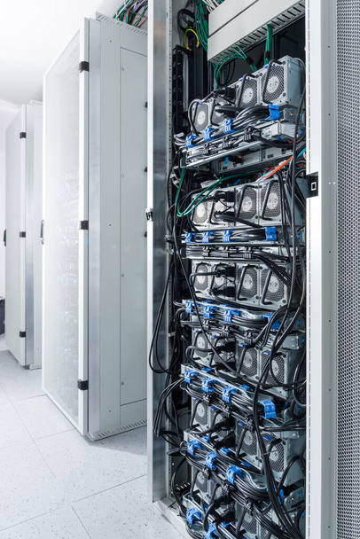 A row of racks with data storage hardware inside server room - Φωτογραφία, εικόνα