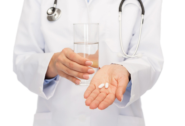 close up of doctor offering pills and water - 写真・画像