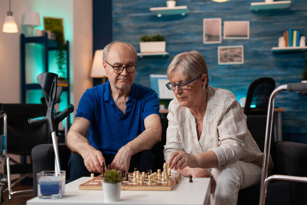 Senior man and woman focused on board game match - Photo, Image