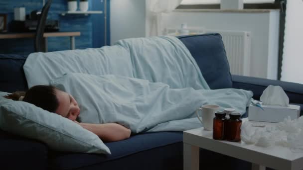 Donna malata sdraiata sul divano con coperta sensazione di freddo - Filmati, video