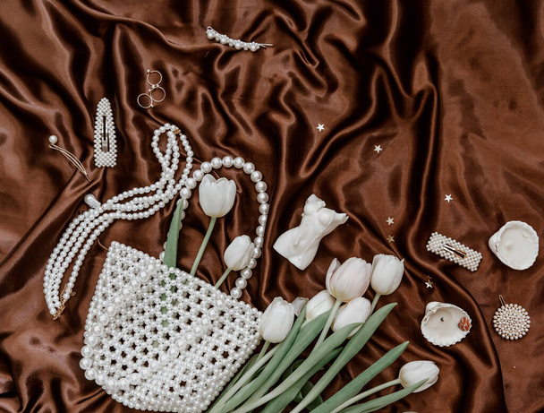 Woman accessories and spring tulips. Elegant feminine flat lay .Elegant silky background.  - Foto, Imagen