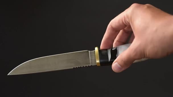 Cuchillo de caza hermoso hecho a mano con una hoja gris afilada sobre un fondo de hormigón oscuro - Metraje, vídeo