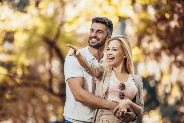 Smiling couple having fun in autumn park - Photo, Image