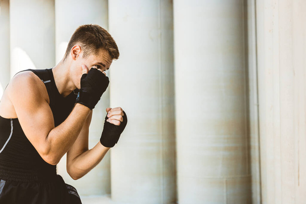 Man exercising and fighting in outside, boxer in gloves. male boxer portrait - Фото, изображение