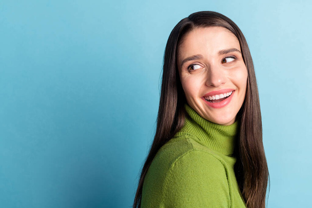 Photo of cheerful inspired lady look back empty space wear green turtleneck isolated on blue background - Foto, Imagem
