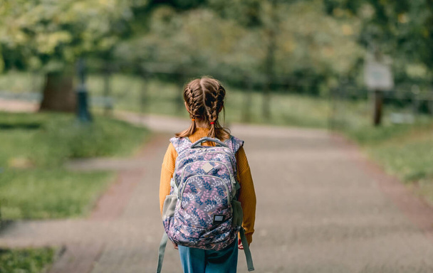 Schoolgirl with backpack outdoors - Фото, зображення