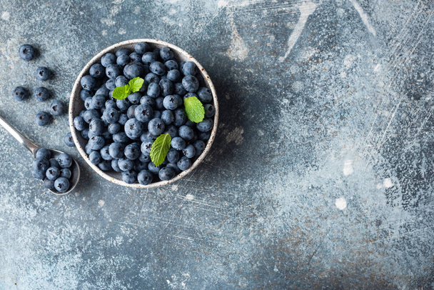 Fresh blueberries in bowl on concrete background - Foto, Imagem
