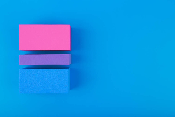 Flat lay with bisexual pride flag made of colorful blocks on blue background. Concept of lgbtq plus community, Pride month, sexual minorities and tolerance - Photo, Image