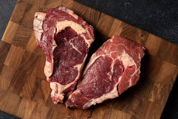 Raw marbled beef steak on a wooden cutting board - Foto, Bild
