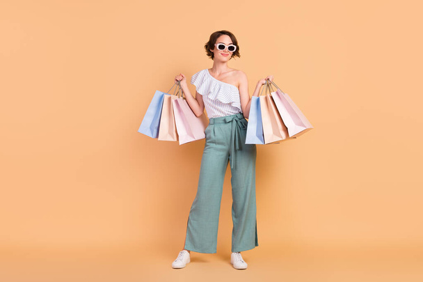 Full length photo of young girl happy positive smile customer shop bags sale isolated over beige color background - Fotoğraf, Görsel
