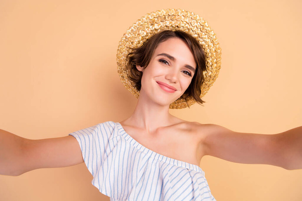 Photo of young attractive girl happy positive smile make selfie wear sunhat vacation isolated over beige color background - Фото, изображение