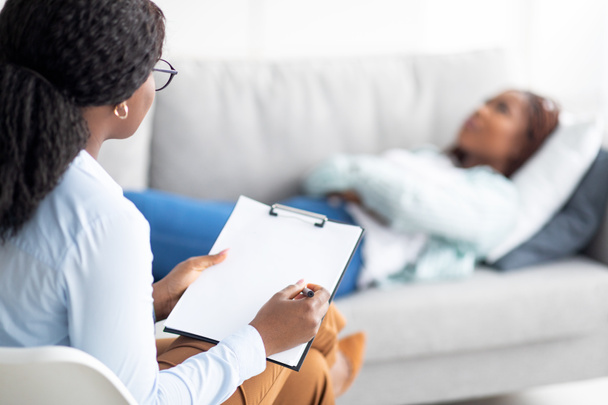 Patiente noire allongée sur un canapé au bureau des psychologues, ayant une session avec un conseiller, recevant un traitement contre la dépression - Photo, image